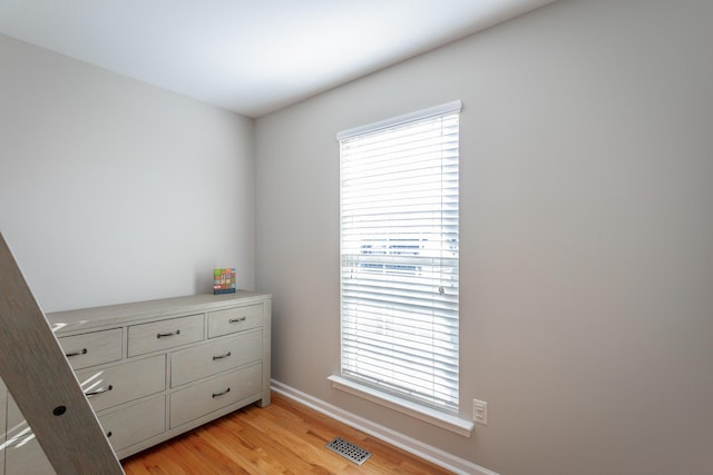 bedroom with light hardwood / wood-style floors and multiple windows