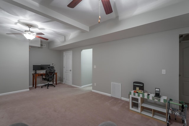 carpeted office space featuring ceiling fan and beam ceiling