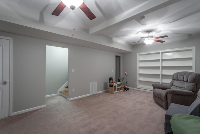 living area with beam ceiling, light carpet, built in features, and ceiling fan