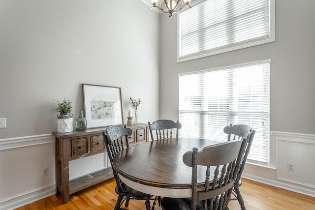 dining room featuring light wood-type flooring and a notable chandelier