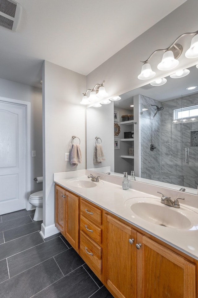 bathroom featuring a shower with shower door, toilet, and vanity