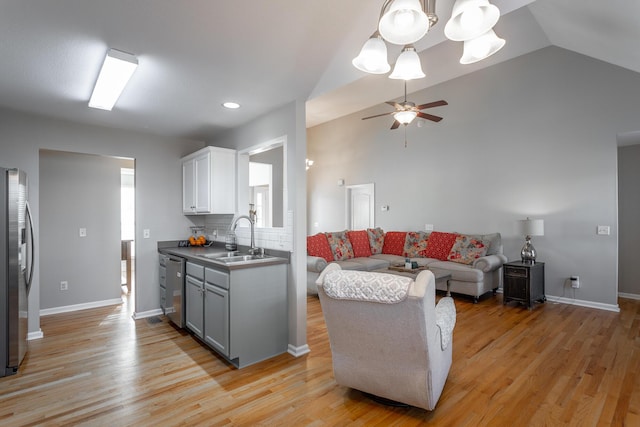 kitchen with appliances with stainless steel finishes, light hardwood / wood-style floors, tasteful backsplash, and sink