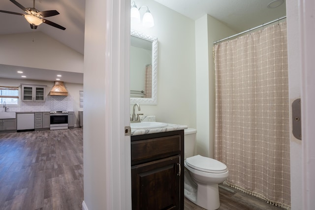 bathroom with vaulted ceiling, hardwood / wood-style floors, tasteful backsplash, vanity, and toilet