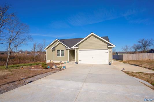 single story home featuring concrete driveway, fence, and a garage