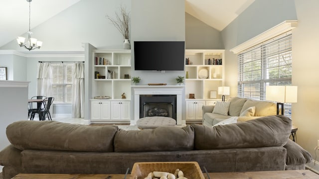 living room with vaulted ceiling, a notable chandelier, and a healthy amount of sunlight