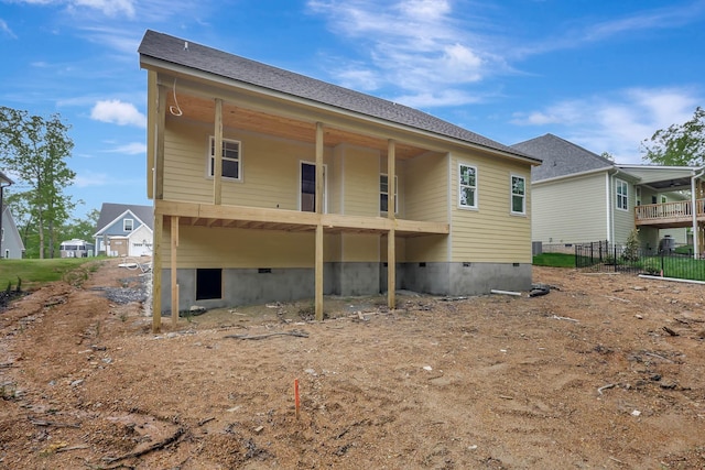 rear view of house featuring fence and crawl space