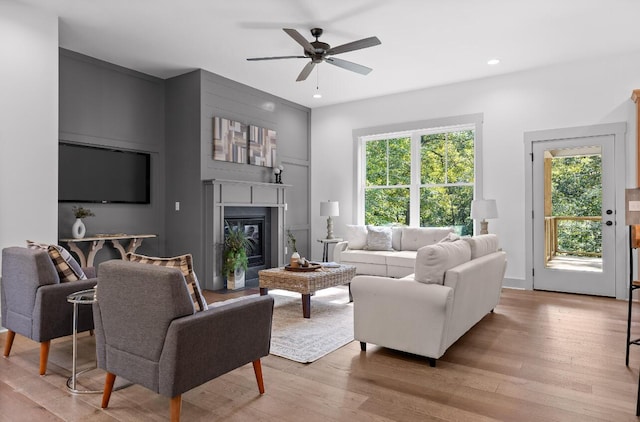 living room featuring ceiling fan and light hardwood / wood-style flooring