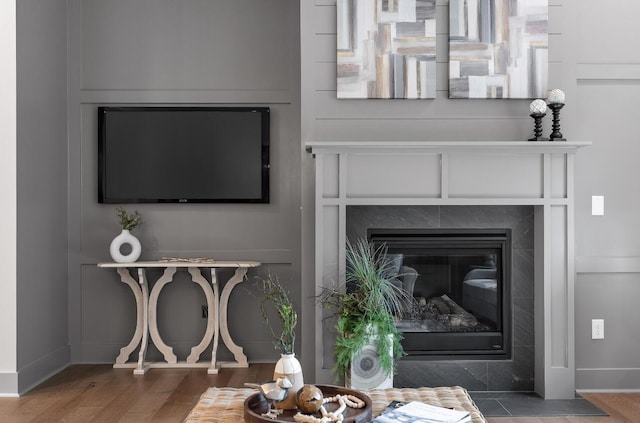 interior details with a tile fireplace and hardwood / wood-style floors