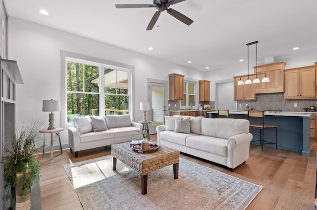 living room with ceiling fan and light hardwood / wood-style floors