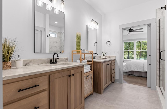 bathroom featuring a shower with shower door and vanity