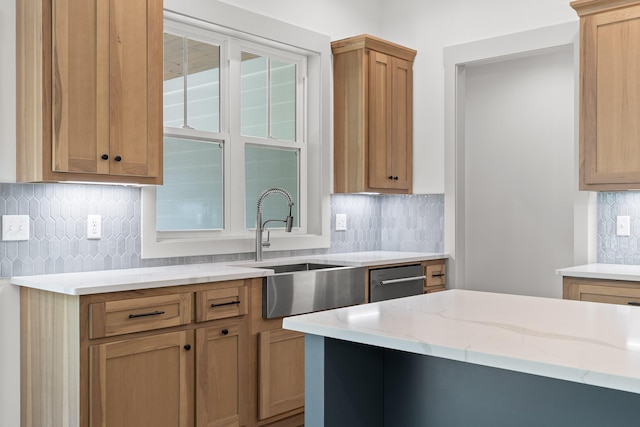 kitchen with backsplash, sink, and light stone counters