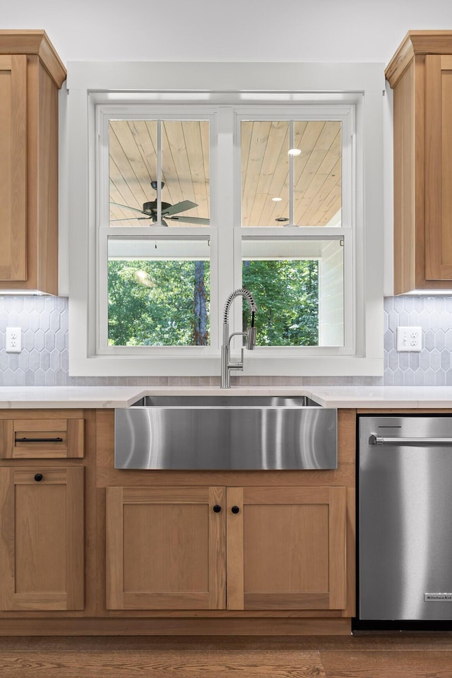 kitchen featuring plenty of natural light, stainless steel dishwasher, tasteful backsplash, and sink