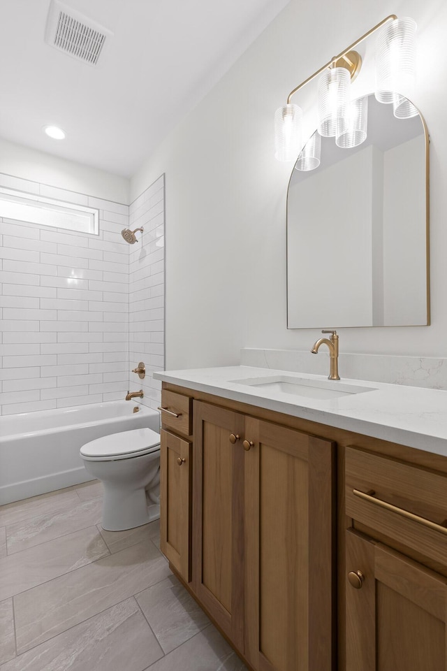 full bathroom featuring toilet, vanity, and tiled shower / bath