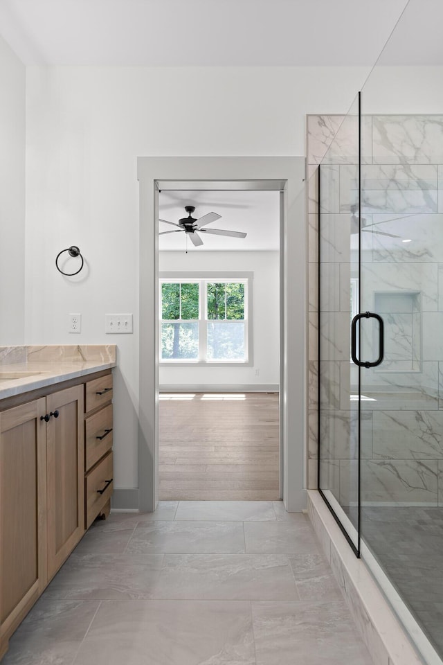 bathroom with an enclosed shower, vanity, ceiling fan, and tile patterned floors