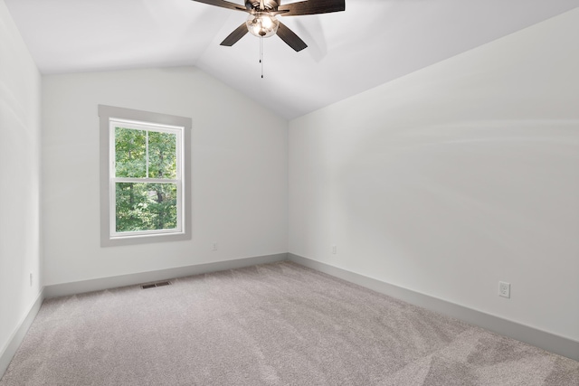 carpeted spare room featuring ceiling fan and lofted ceiling