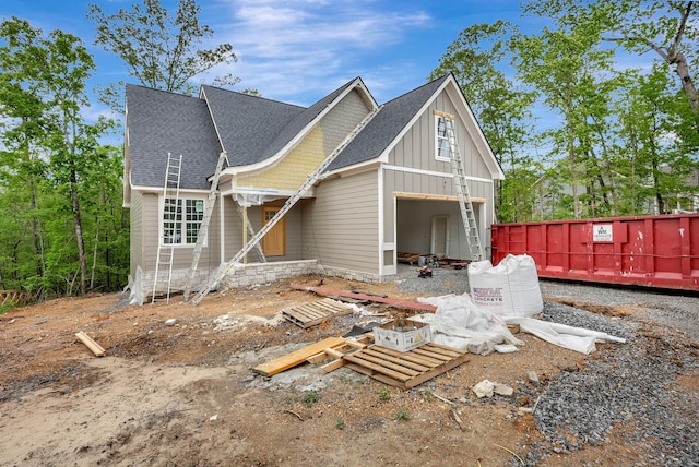 back of house featuring board and batten siding and roof with shingles