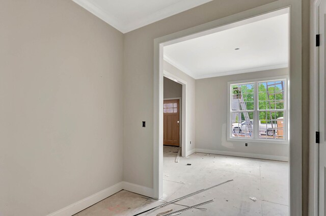 spare room featuring crown molding and baseboards