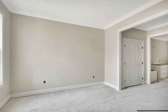 spare room featuring crown molding and baseboards