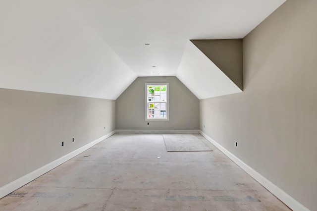 bonus room with lofted ceiling and baseboards