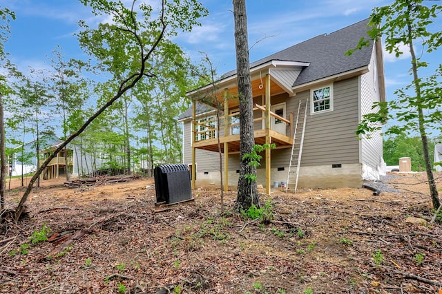 back of property featuring a shingled roof and crawl space