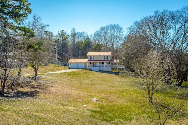 view of front facade with a garage, a porch, and a front lawn