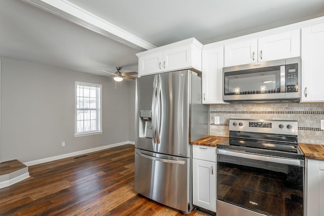 kitchen featuring stainless steel appliances, white cabinetry, and butcher block counters