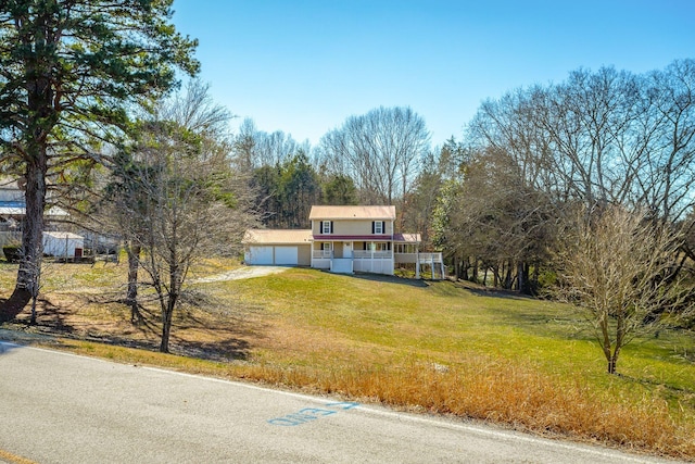 view of front of house featuring a front yard, a porch, and a garage