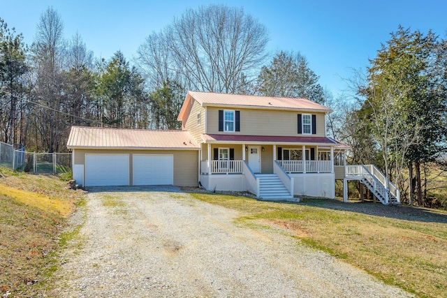 view of property with a porch, a garage, and a front lawn