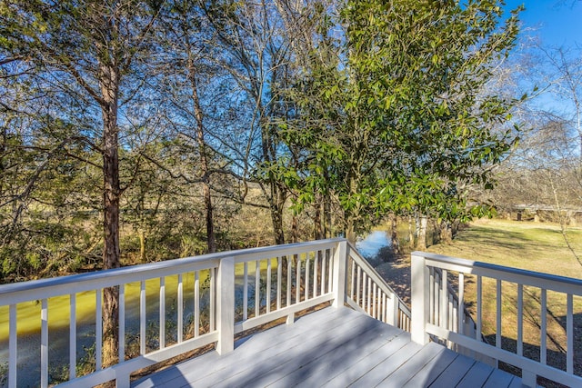 wooden deck with a lawn and a water view