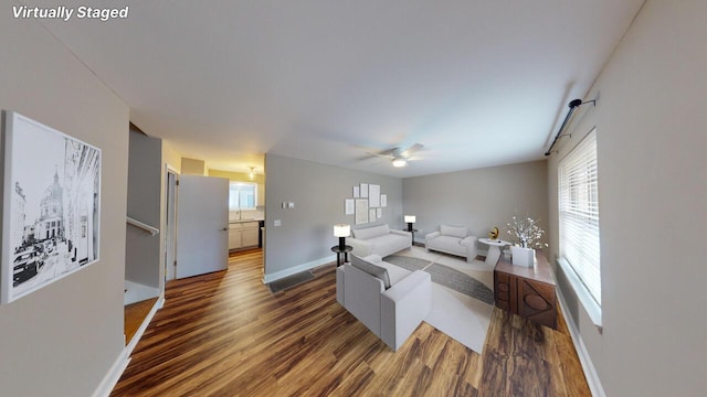 living room featuring ceiling fan and dark hardwood / wood-style flooring