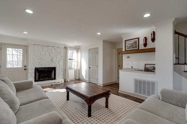 living room featuring dark hardwood / wood-style flooring, crown molding, and a fireplace