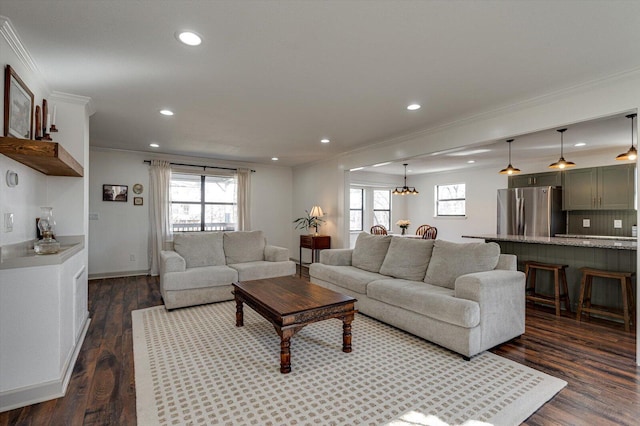 living room featuring dark wood-type flooring, a wealth of natural light, and crown molding