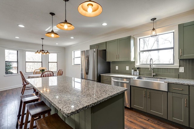 kitchen featuring sink, pendant lighting, a center island, and stainless steel appliances