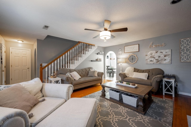 living room featuring wood-type flooring, a textured ceiling, and ceiling fan