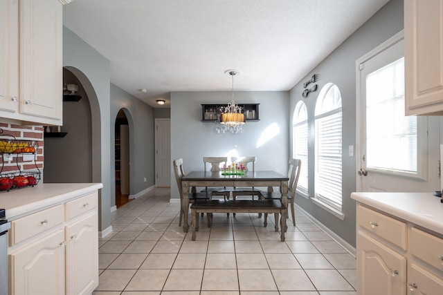 tiled dining room featuring a textured ceiling