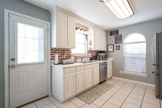 kitchen with sink, light tile patterned floors, white cabinets, and appliances with stainless steel finishes