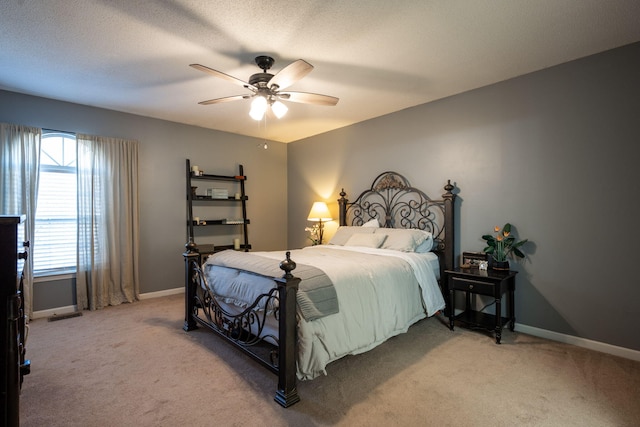 bedroom with ceiling fan, carpet, and a textured ceiling