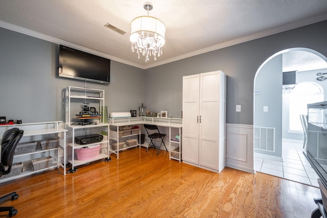 office with a notable chandelier, crown molding, light hardwood / wood-style floors, and a textured ceiling