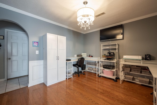 office with hardwood / wood-style floors, a textured ceiling, a notable chandelier, and ornamental molding