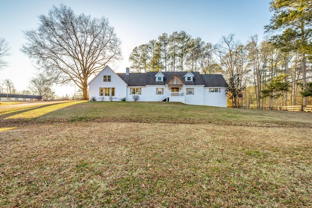 cape cod-style house with a front yard