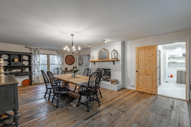 dining area with a chandelier, a fireplace, and dark hardwood / wood-style flooring