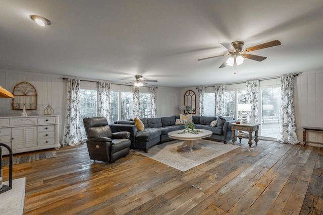 living room featuring ceiling fan, a healthy amount of sunlight, and dark hardwood / wood-style flooring