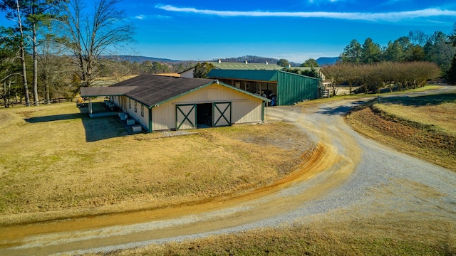 view of outbuilding with a mountain view and a lawn