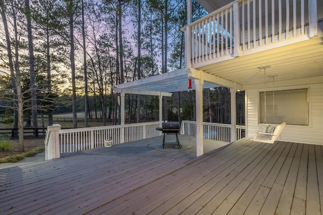 deck at dusk featuring a pergola