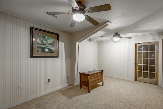 carpeted spare room with crown molding and ceiling fan