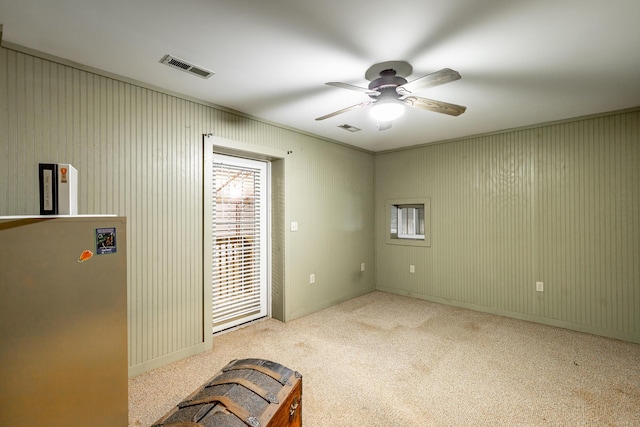 interior space with plenty of natural light, light colored carpet, and ceiling fan