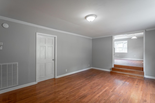 empty room with hardwood / wood-style flooring and crown molding