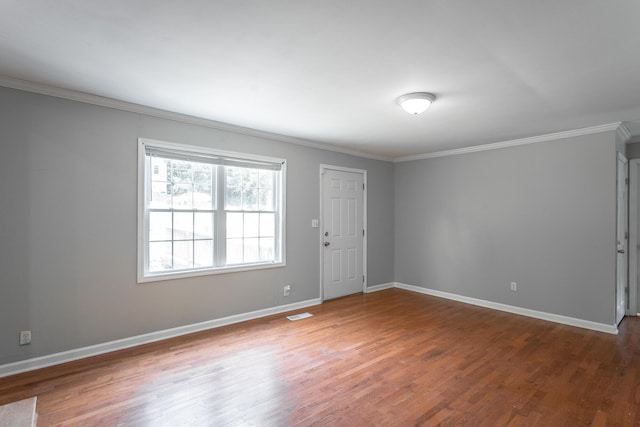 spare room featuring crown molding and wood-type flooring