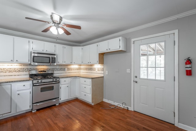 kitchen with white cabinets, stainless steel appliances, tasteful backsplash, ornamental molding, and ceiling fan