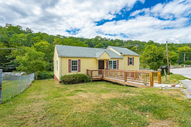 view of front of property featuring a wooden deck and a front lawn